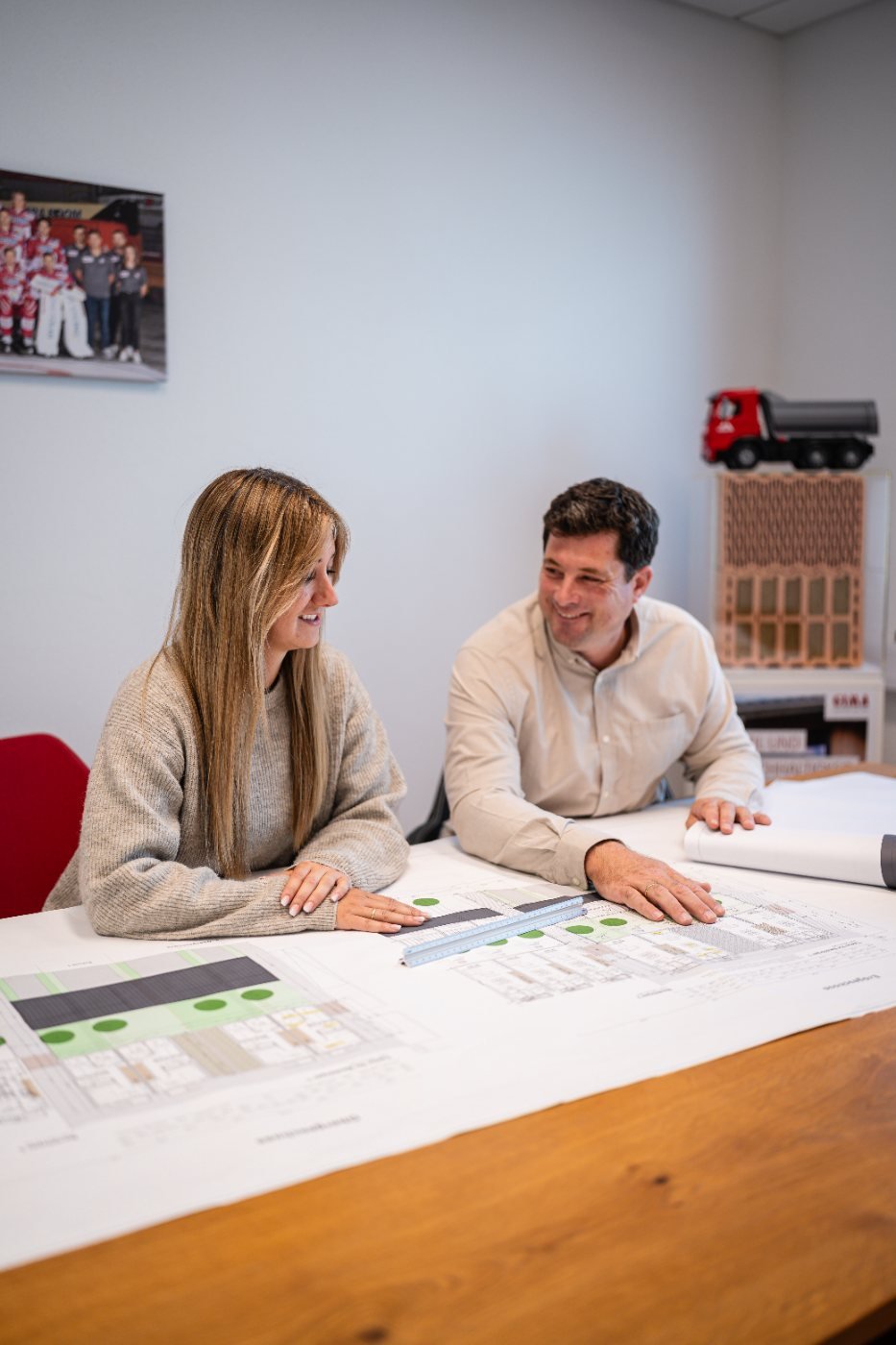 Frau und Mann am Bauplan im Büro